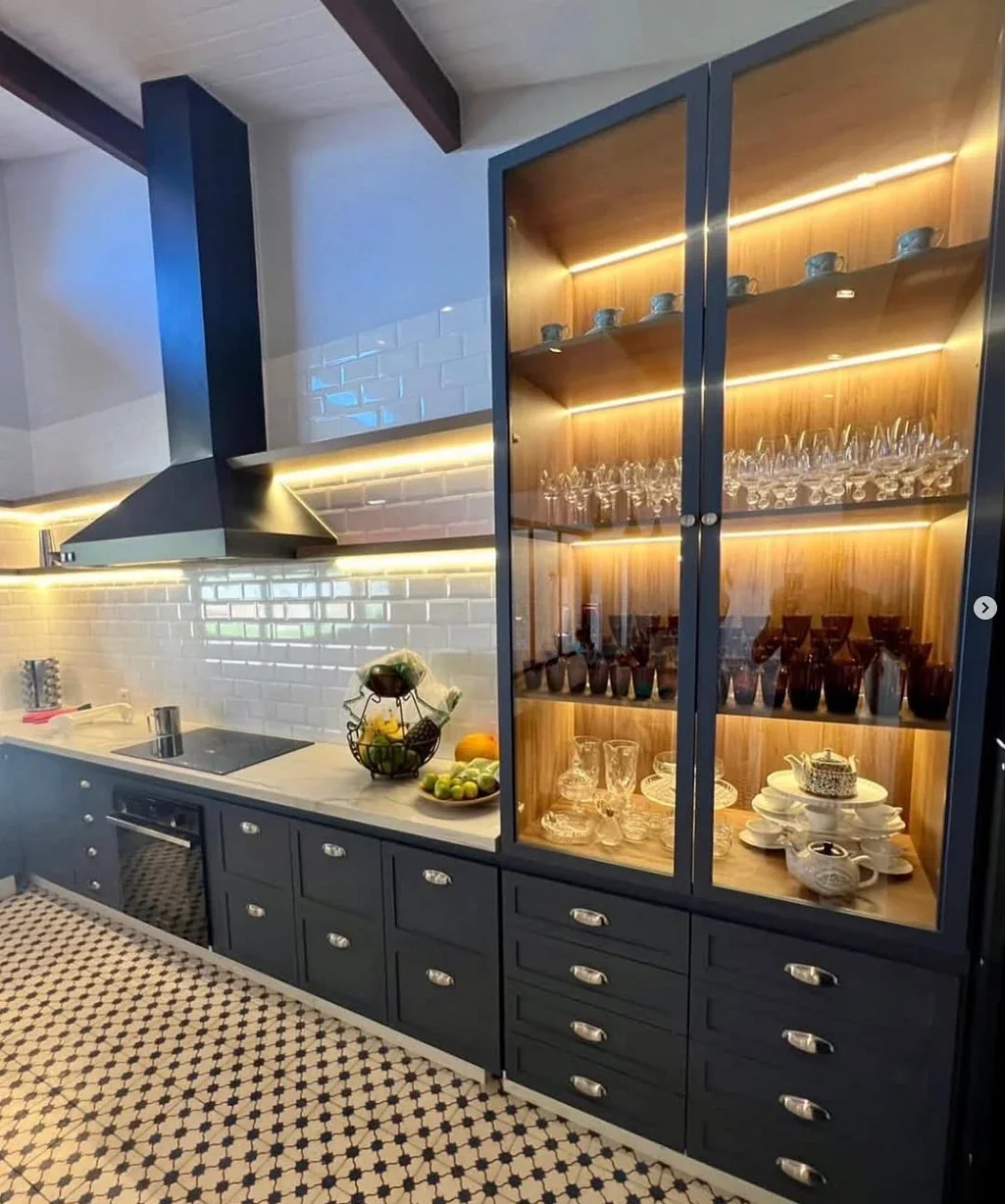 Cozinha planejada azul-marinho com cristaleira iluminada